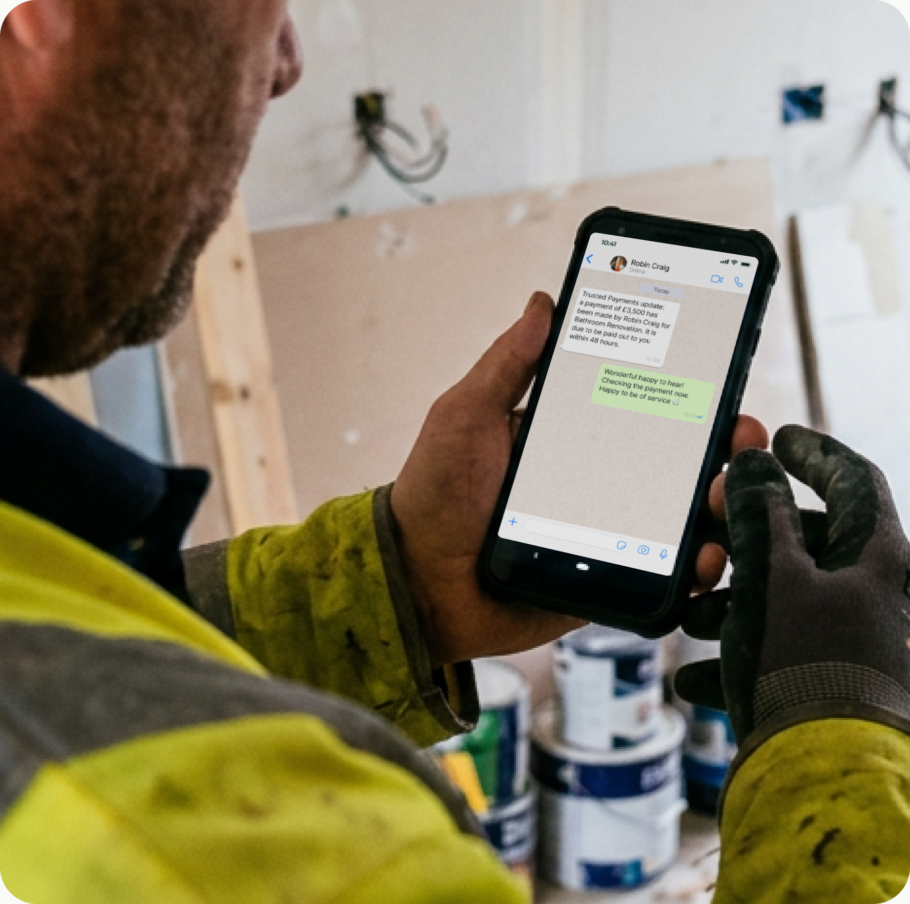 Tradesperson reviewing a project update on the Trusted Payments app